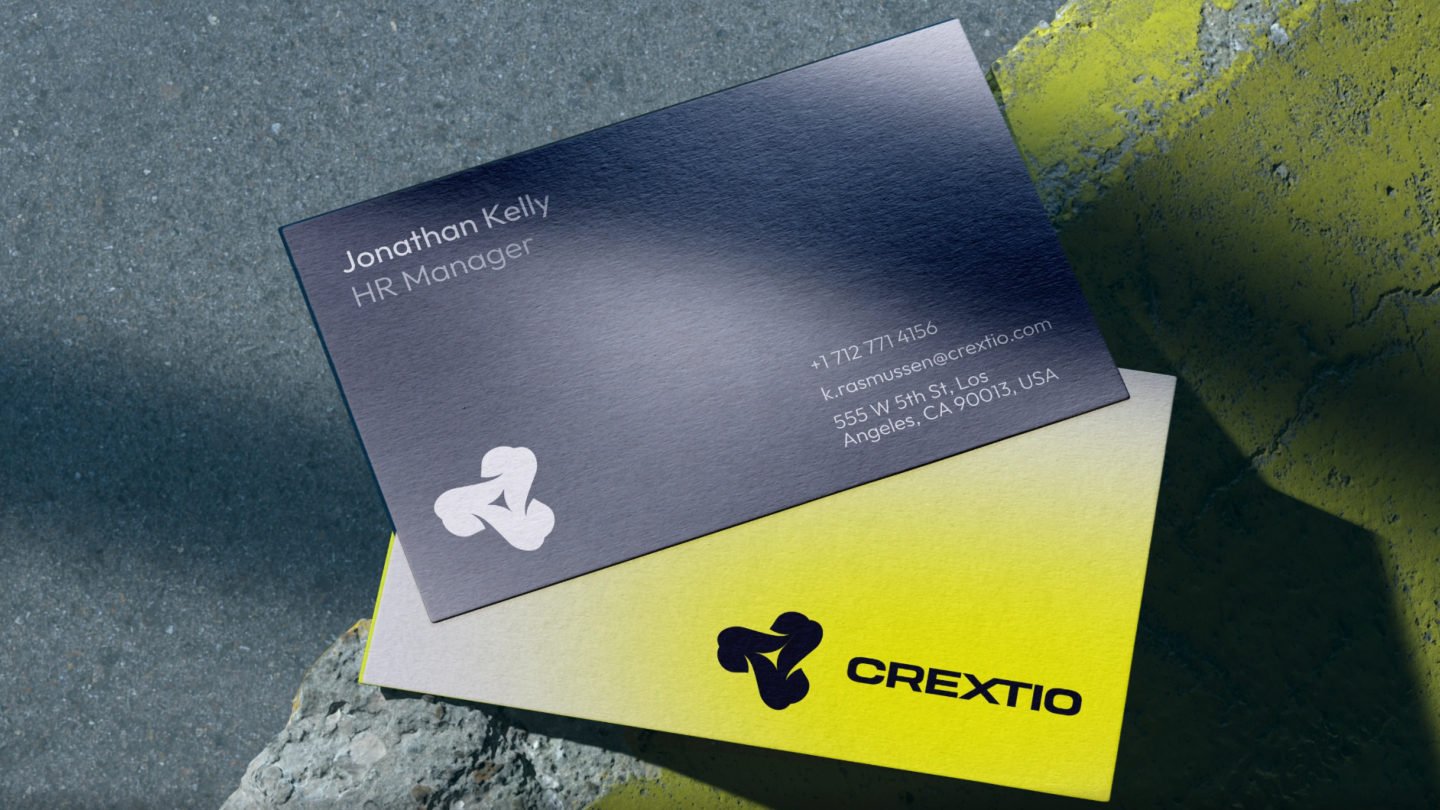 Crextio business cards in dark navy and yellow on concrete